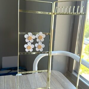 Daisy clay earrings. The metal is silver. They’re about 2 1/2 inches.